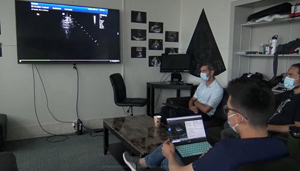 Research team looping at ultrasound image on screen 