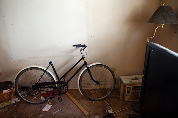 A bike in a cluttered and messy room 