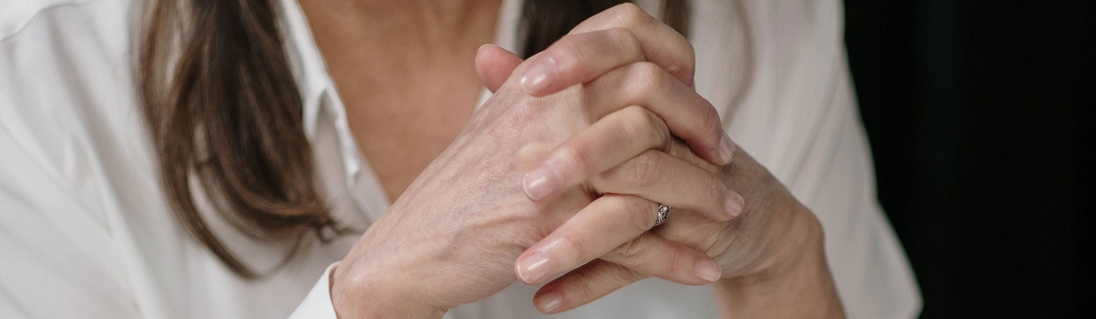 Woman clasps her hands
