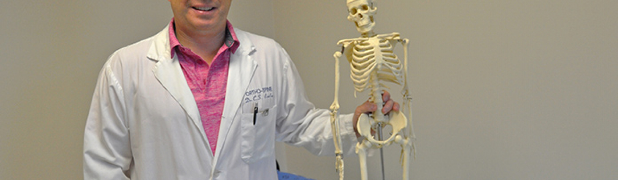 Dr. Chris Bailey with a miniature skeleton 